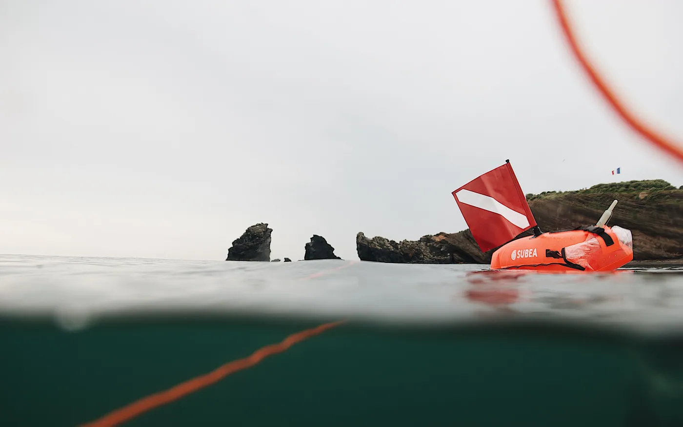 A dive flag mounted on an inflatable surface float in the water