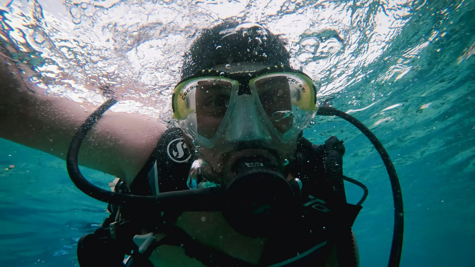 A scuba diver at the surface with the regulator in and mask on