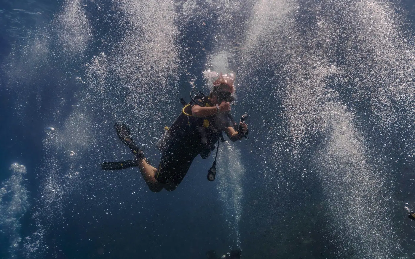 A scuba diver rising through a column of bubbles