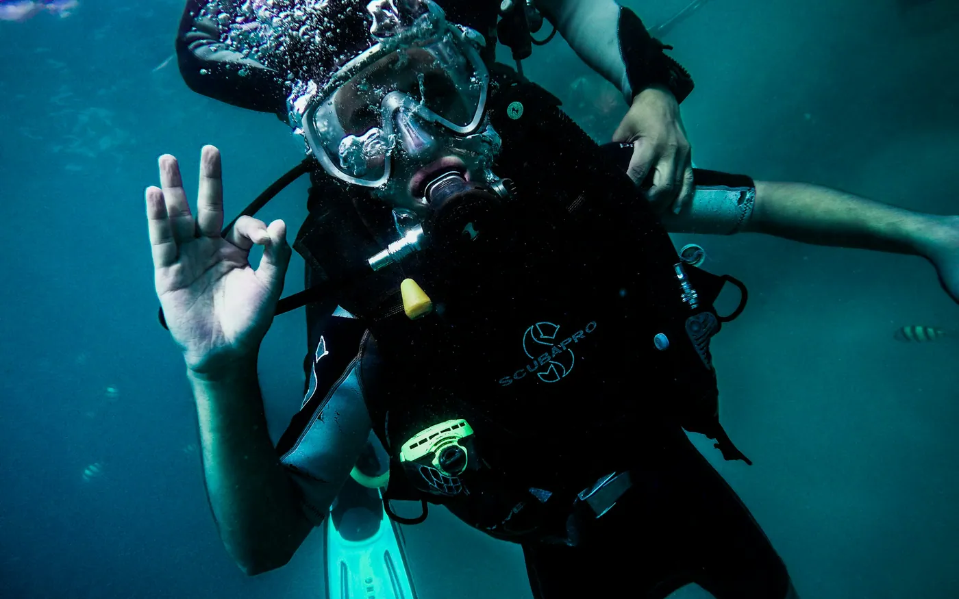 A scuba diver underwater giving the OK signal