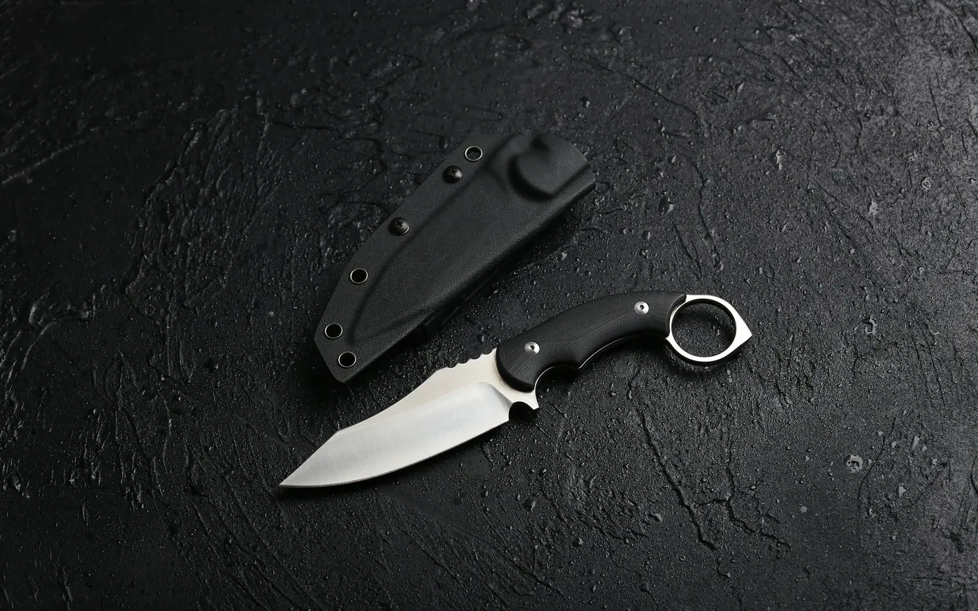 A small folding knife lying beside its sheath