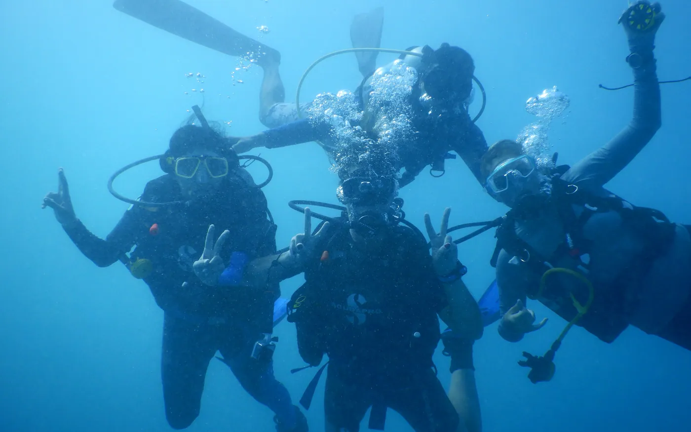 A group of four scuba divers together in mid water