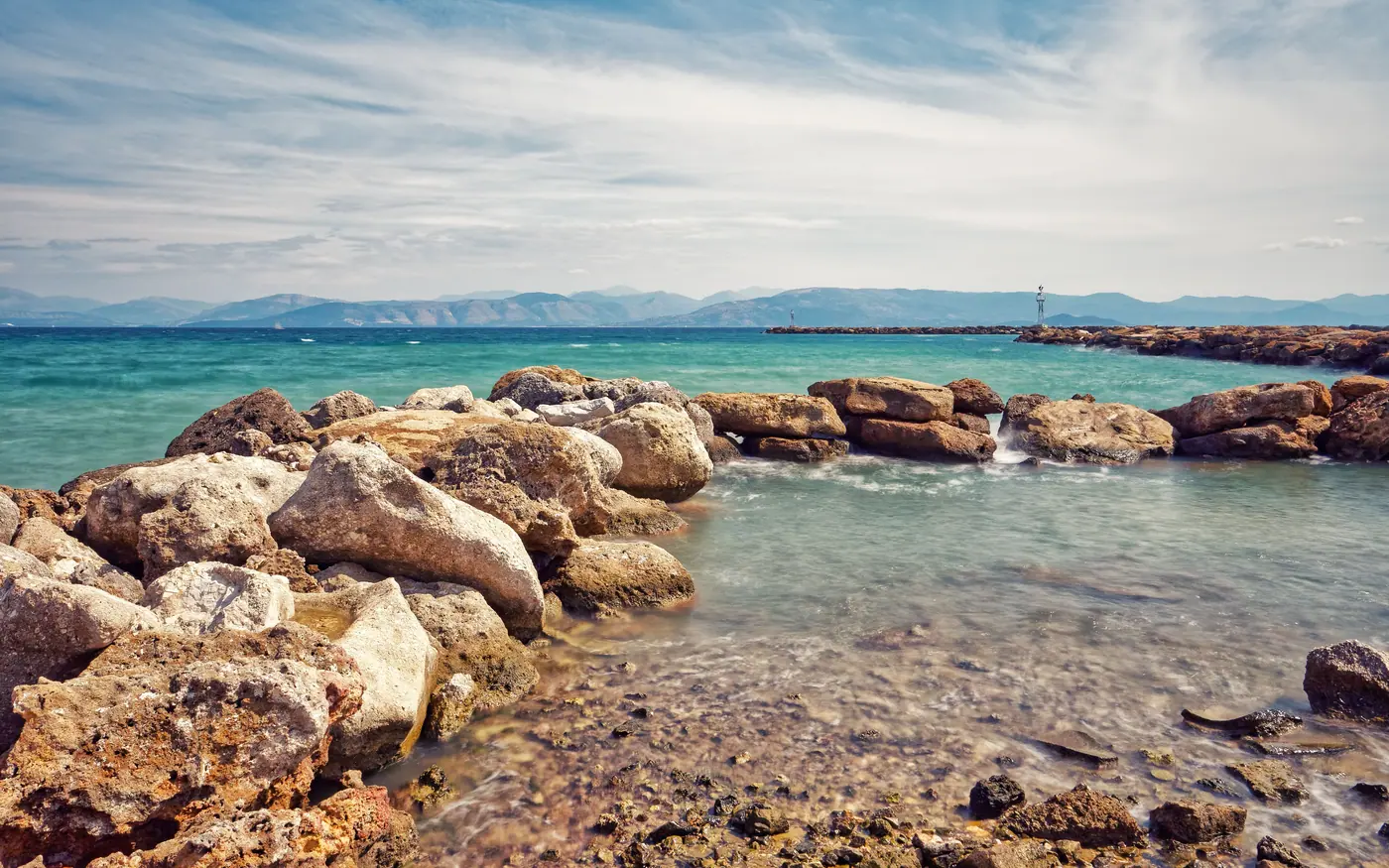 A gently sloping rocky shore meeting shallow clear water