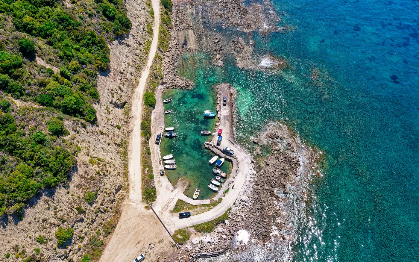 A slipway and small boats in a sheltered rocky cove