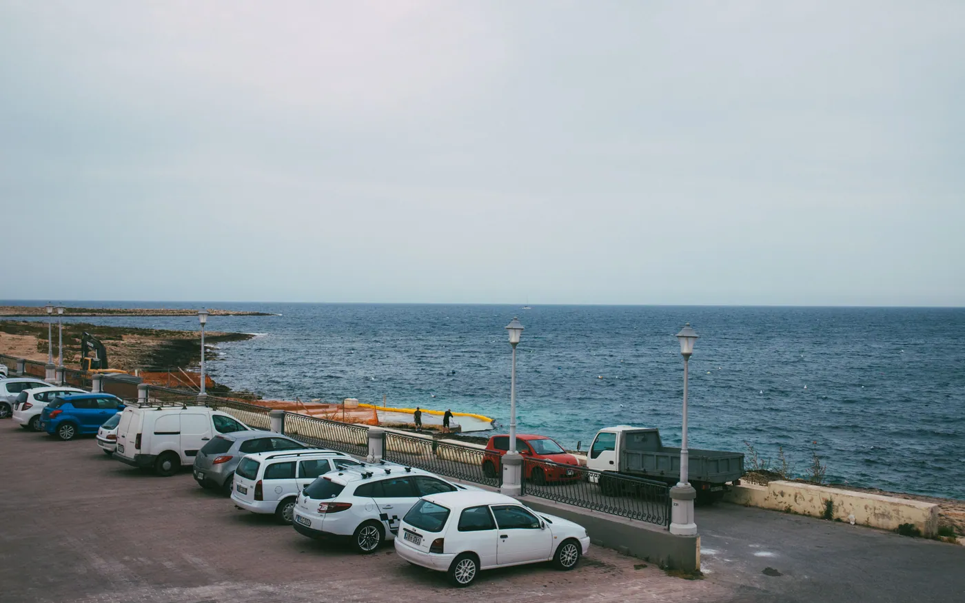 A small parking area at the edge of a rocky shore