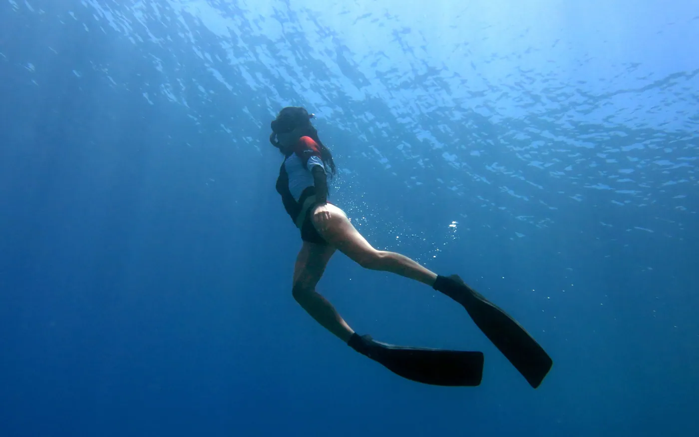 A snorkeler finning gently just below the surface