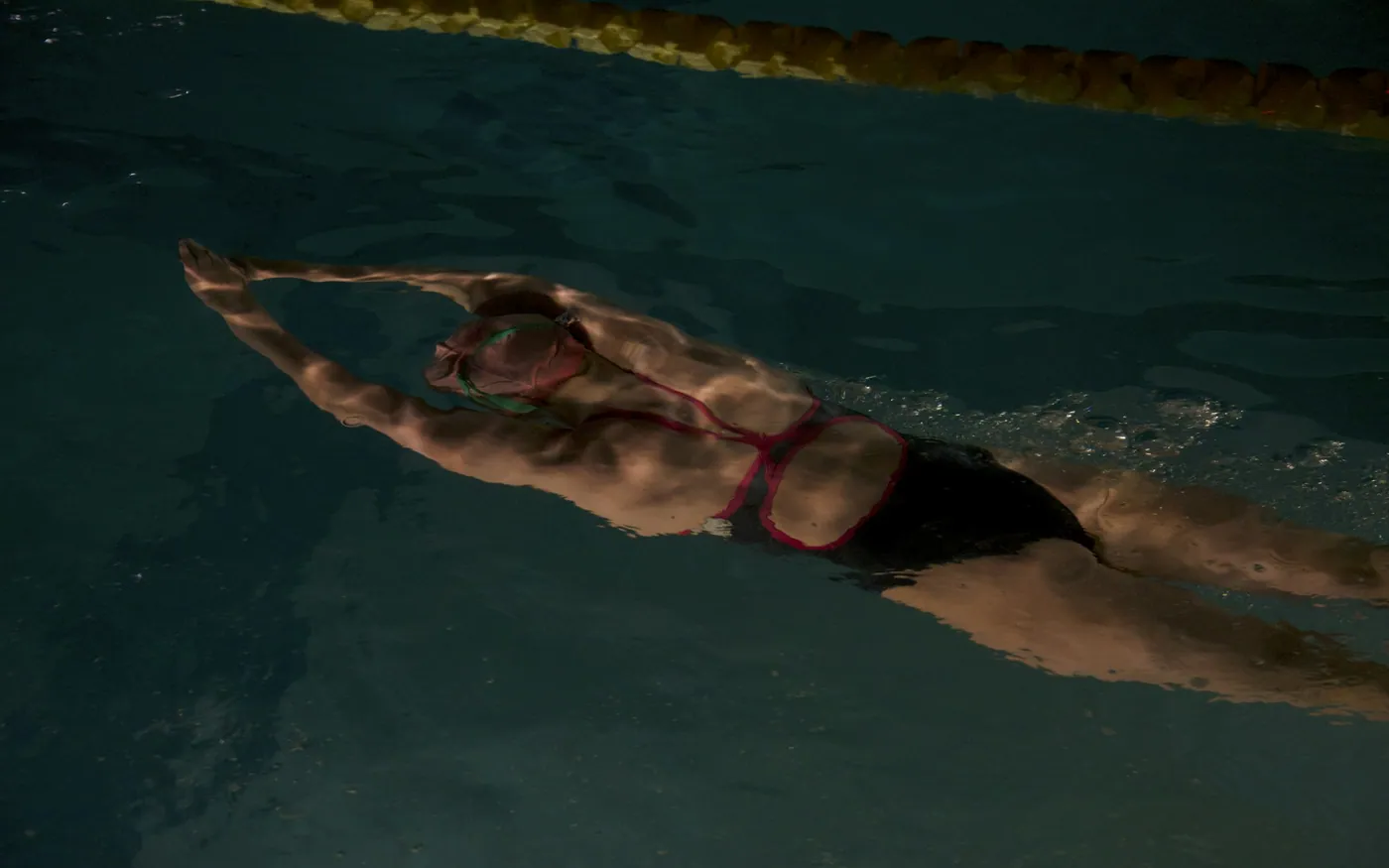 A swimmer gliding underwater in a streamlined position