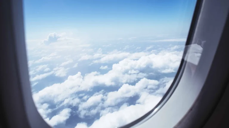 The view from an airplane window above the clouds