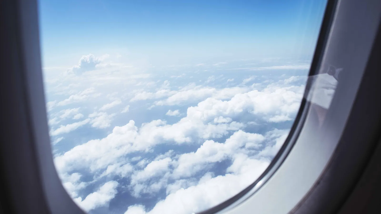 The view from an airplane window above the clouds