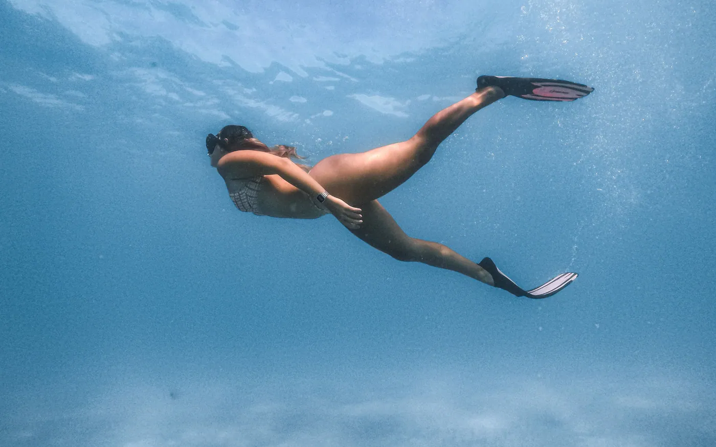 A snorkeler descending a short way on a single breath
