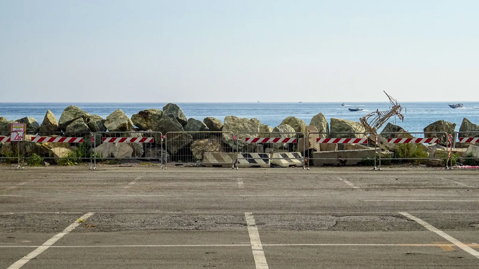 An empty seafront parking area behind a low sea wall