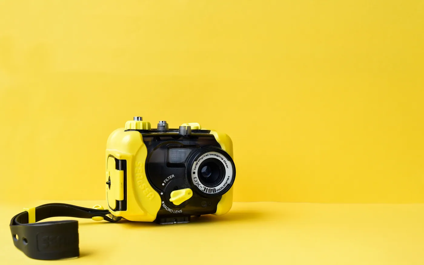 A yellow underwater camera housing photographed against a plain background