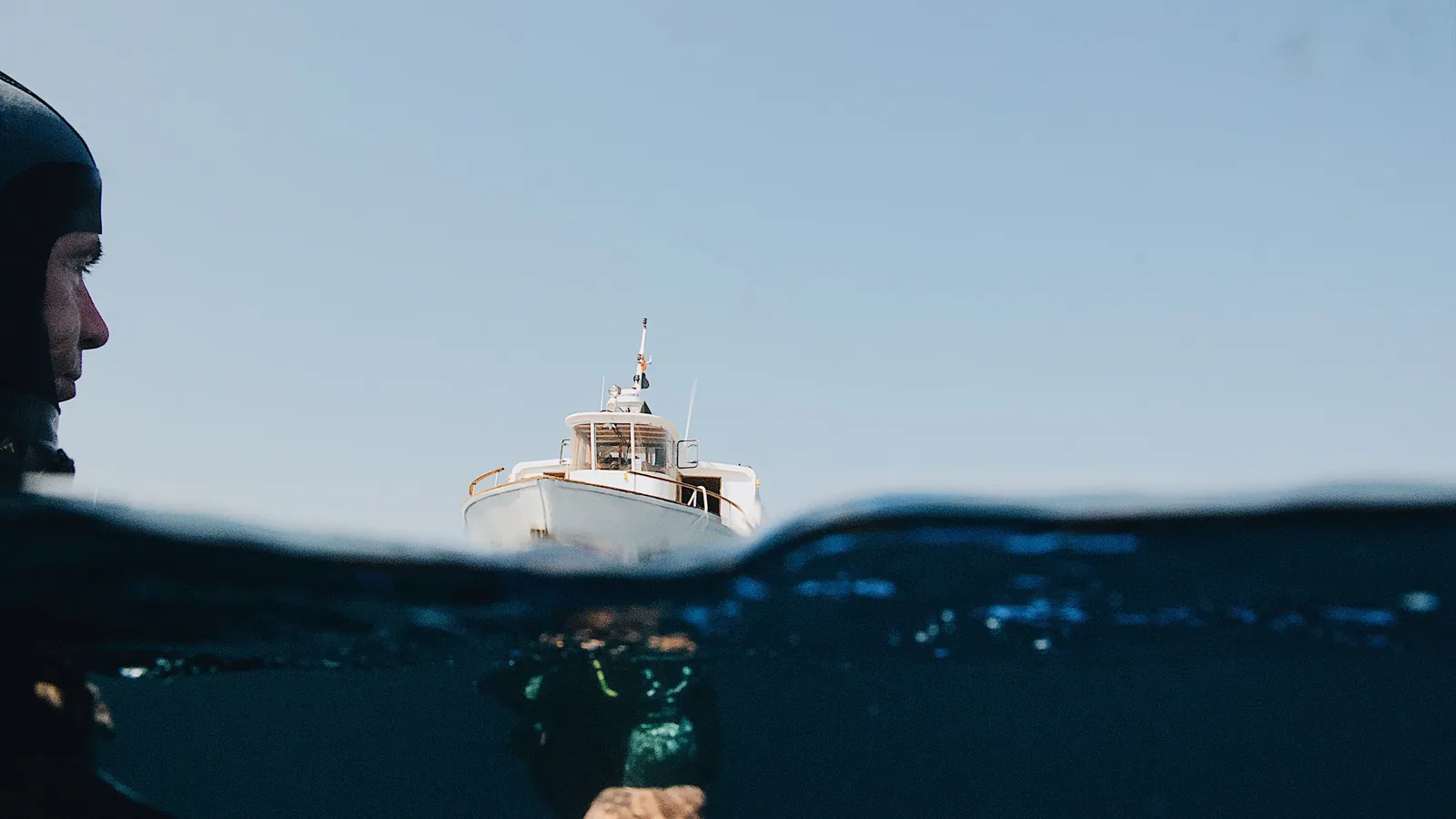A split-level view of a boat on the surface with a diver below