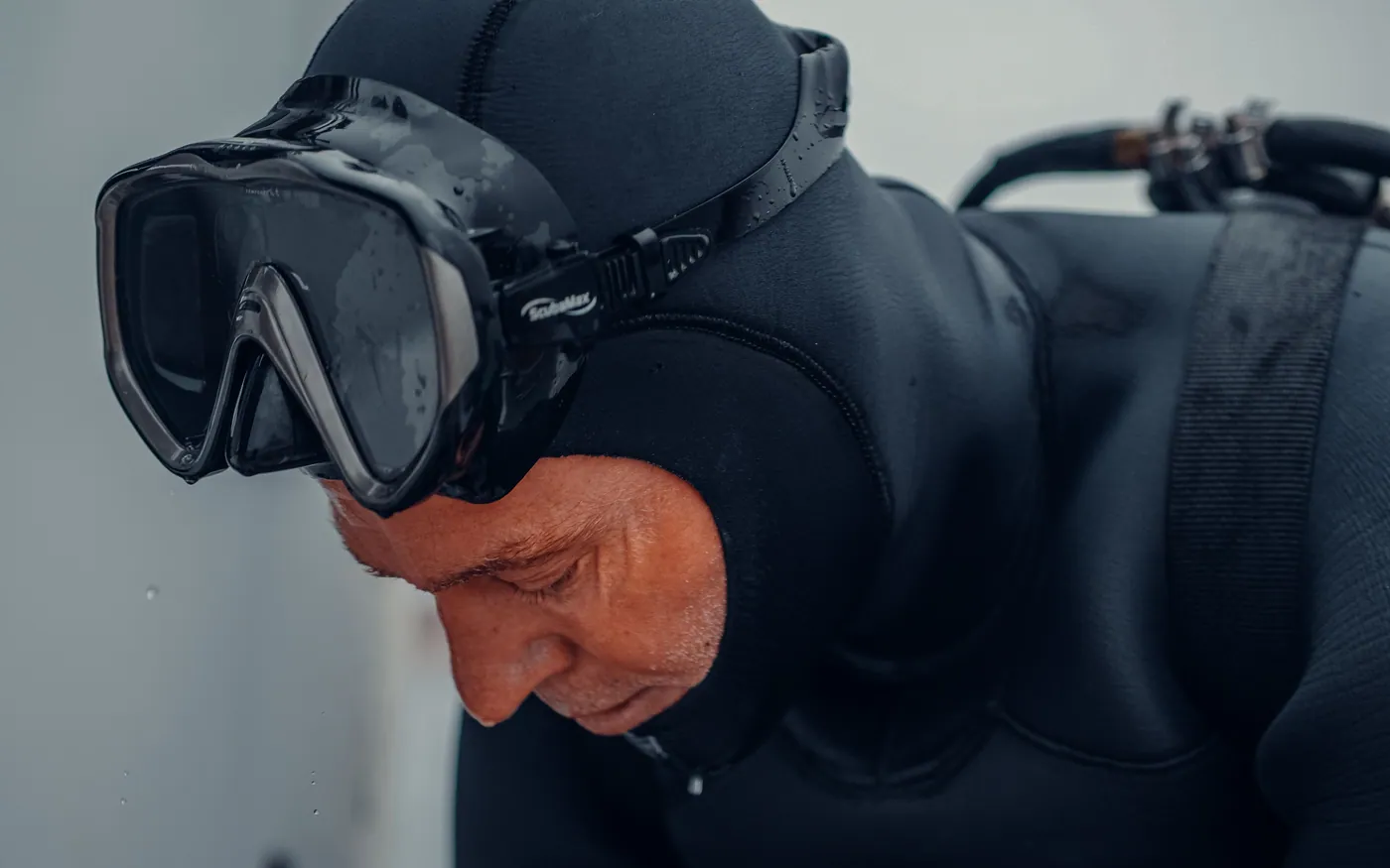 Close-up of a diver in a neoprene hood and mask before a cold dive