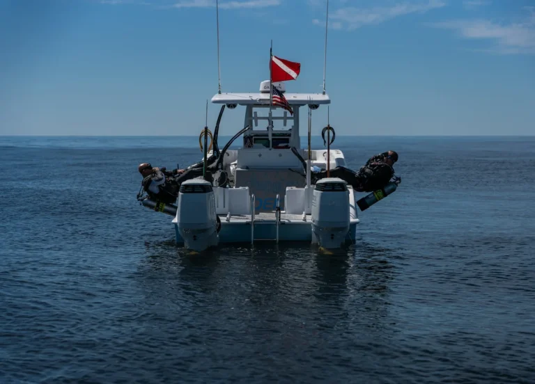 A dive boat flying the diver-down flag on open blue water
