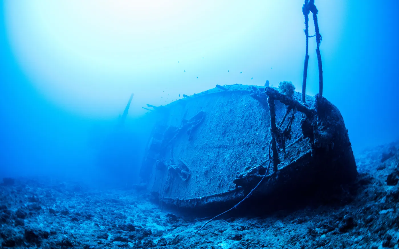 A shipwreck on the seabed with a descent line running up toward the surface