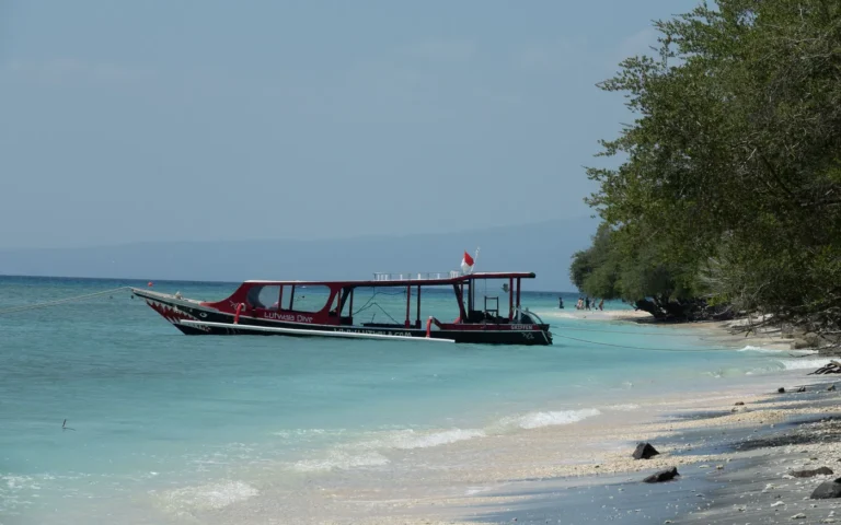A dive boat moored off a quiet tropical beach