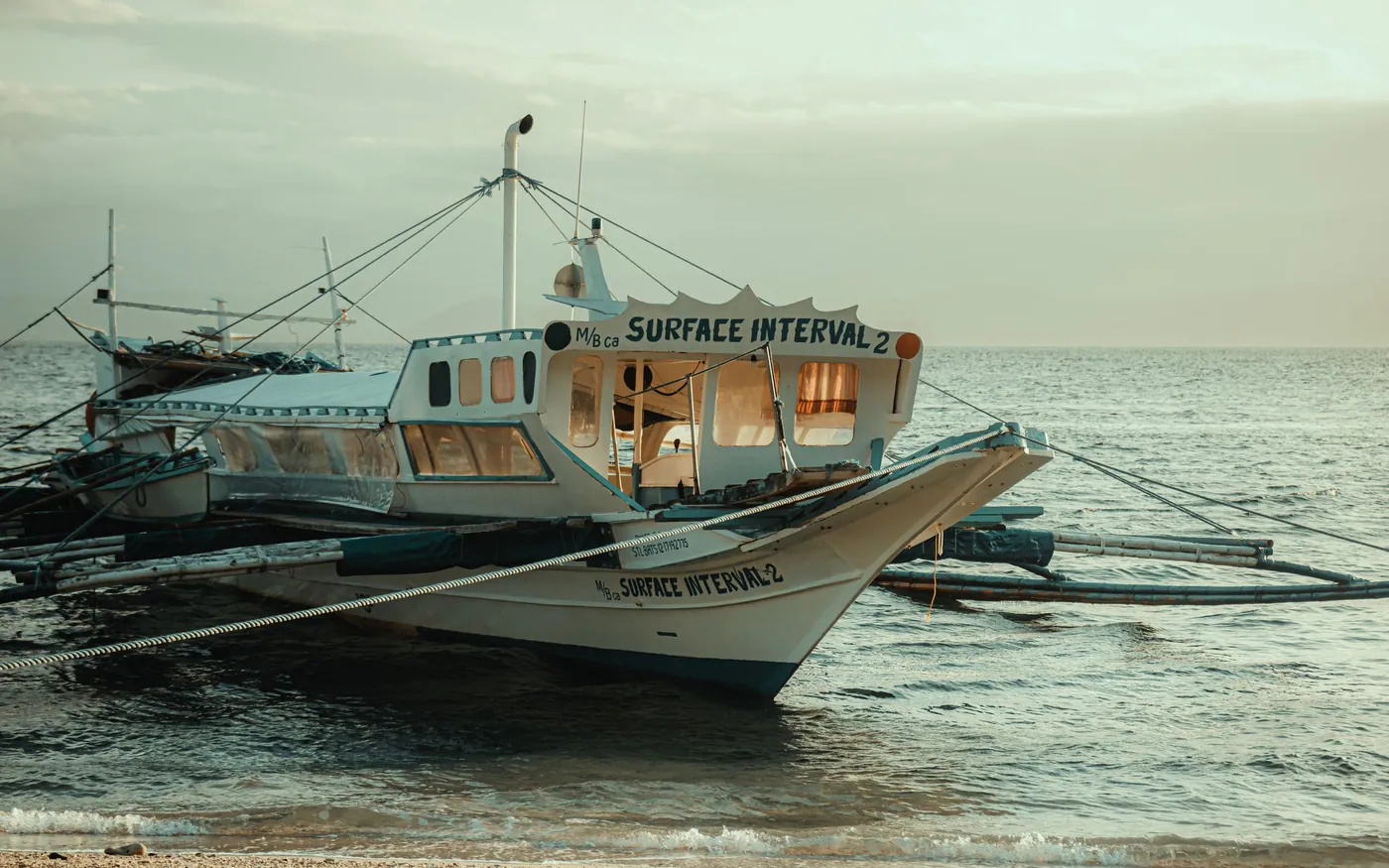 A dive boat named Surface Interval drawn up on a beach