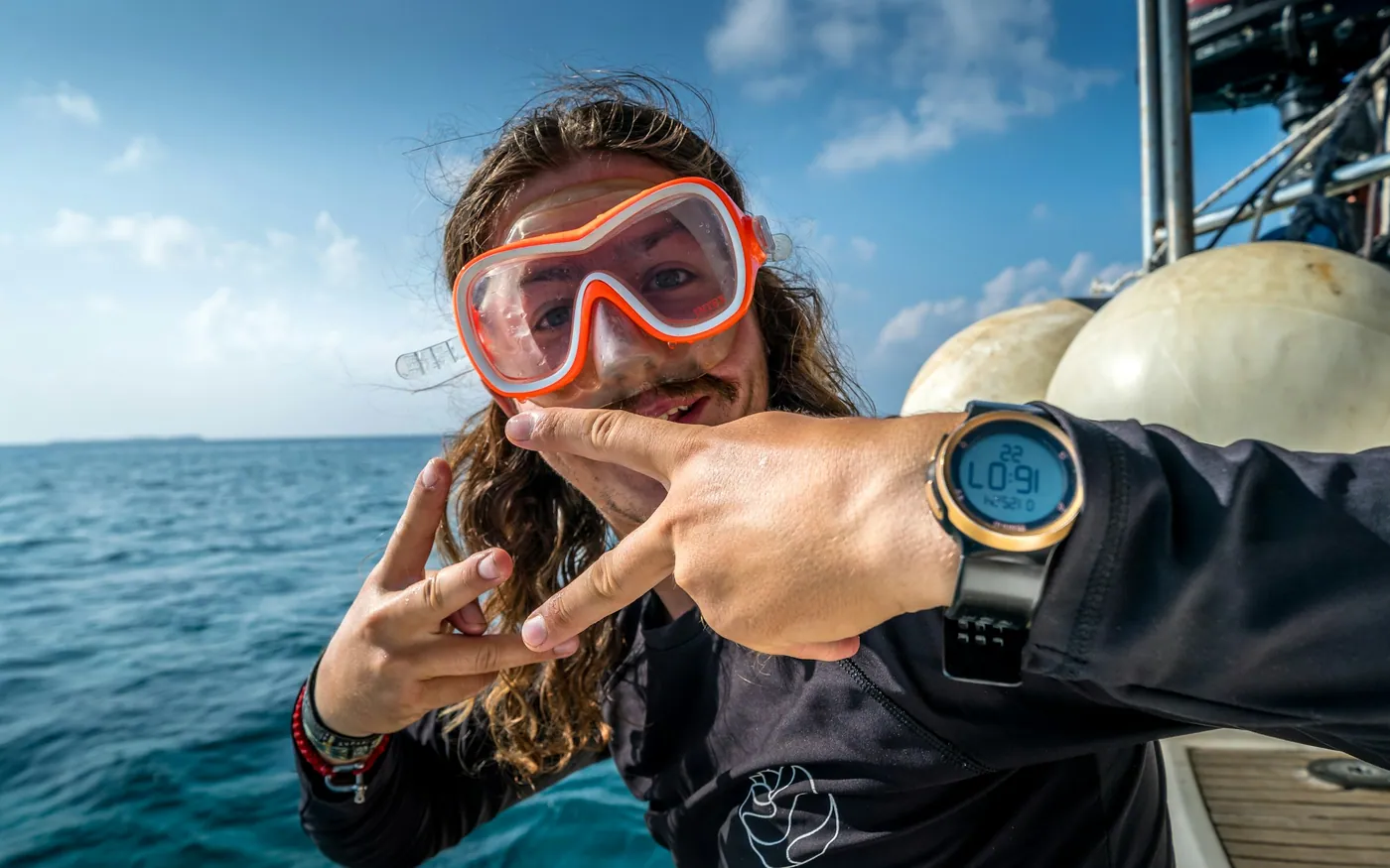 A diver at the surface in a mask, signalling after a session