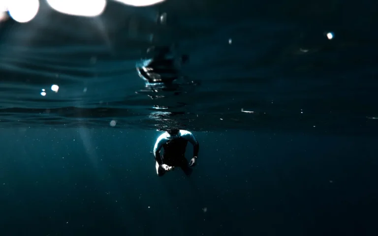 A diver at the surface in dark water after a dive