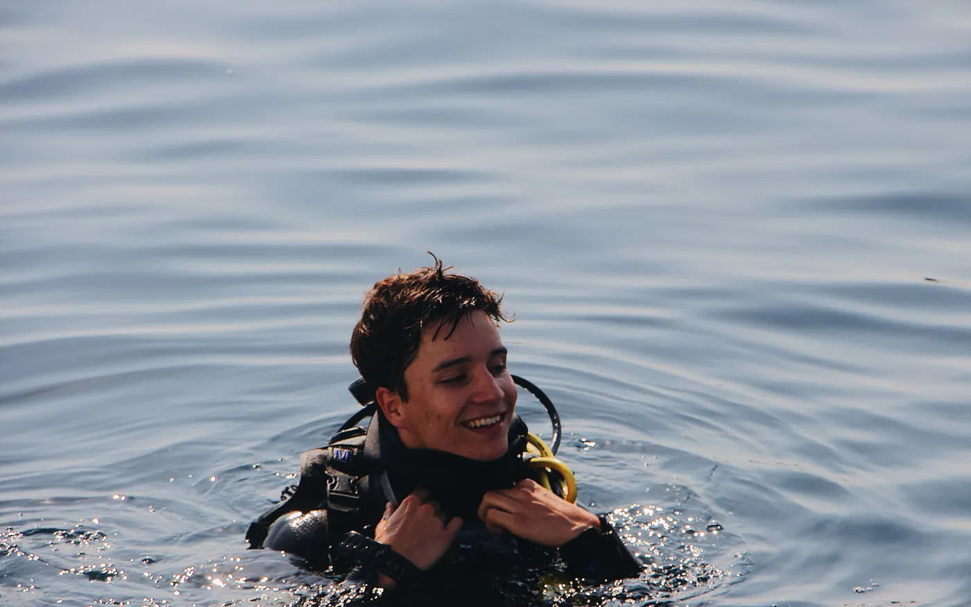 A diver at the surface after a dive, signalling to the boat