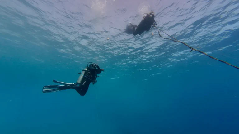 A scuba diver following a line running up toward the surface