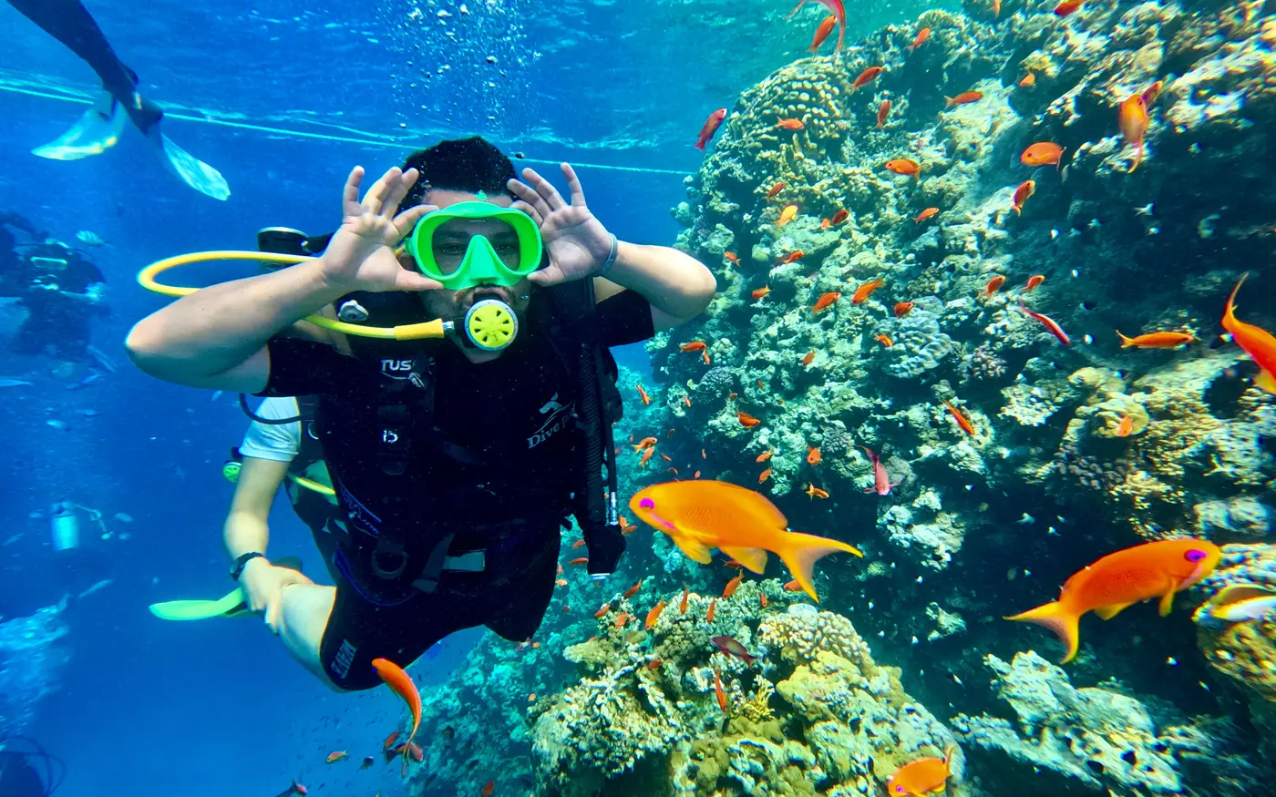 A scuba diver giving the OK signal underwater