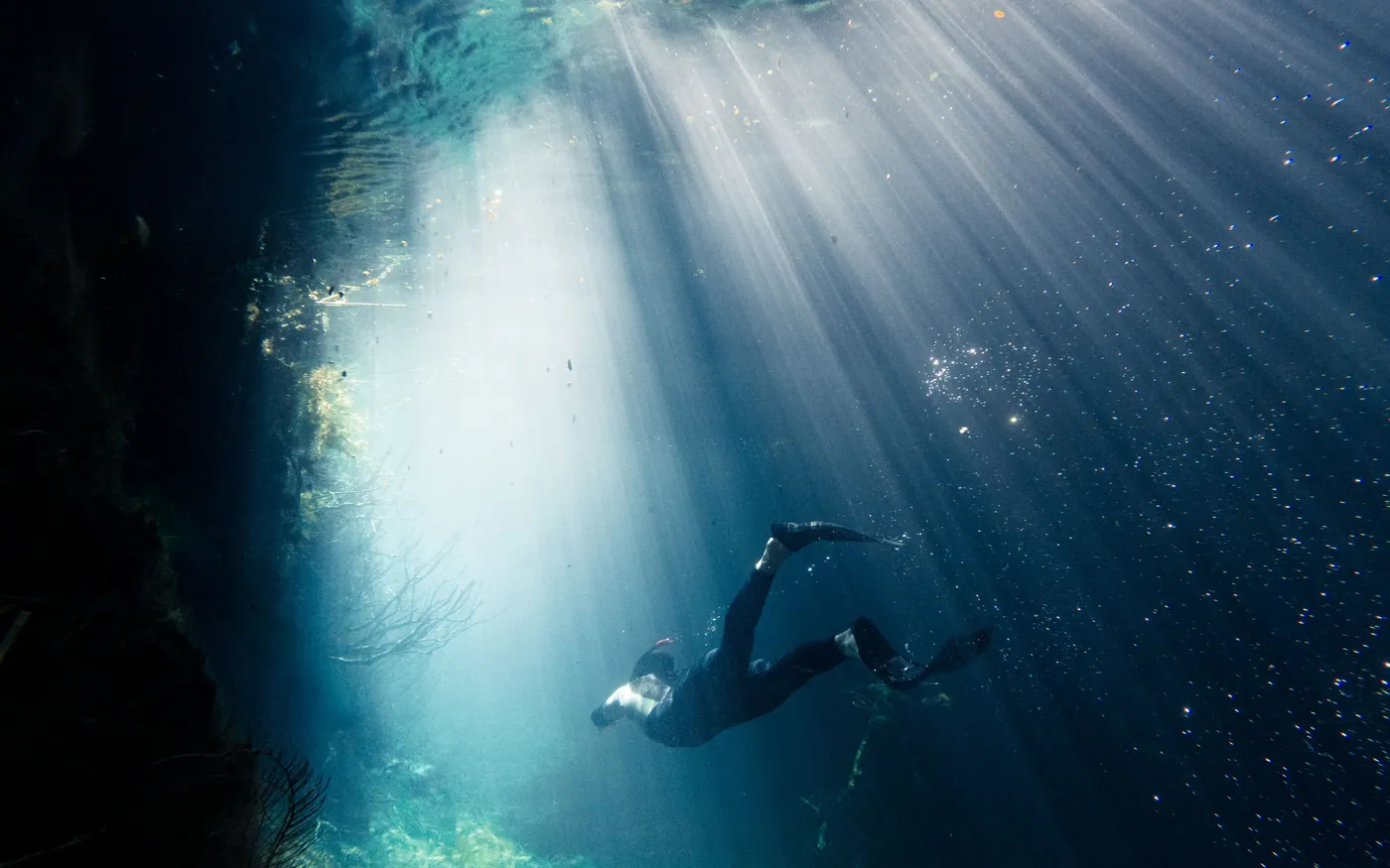 A scuba diver in shafts of light with no visible landmarks