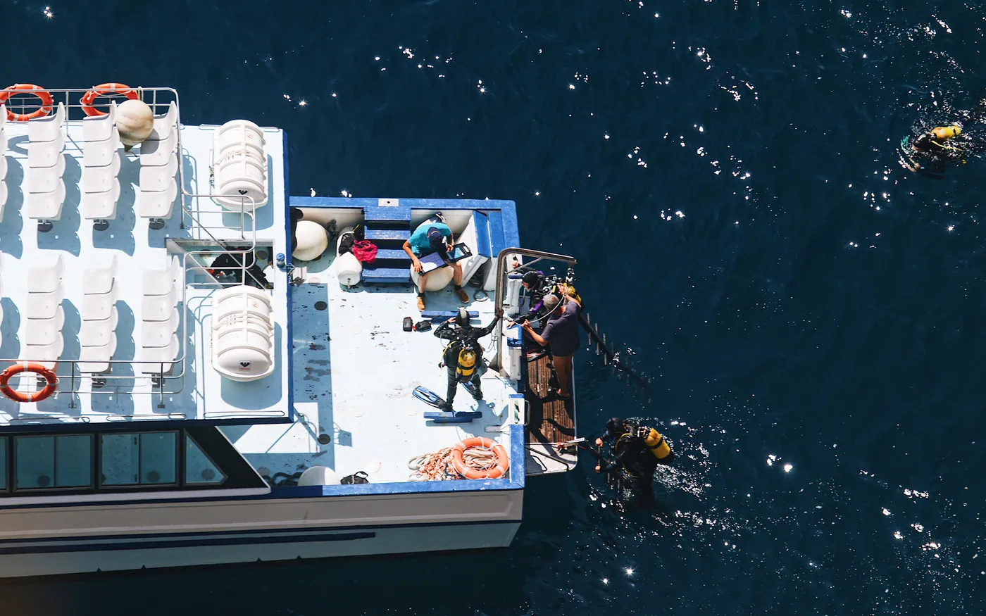 A dive boat seen from above with divers in the water