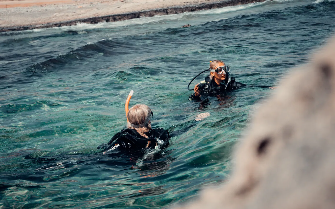 Two divers floating at the surface, where a weight check is done
