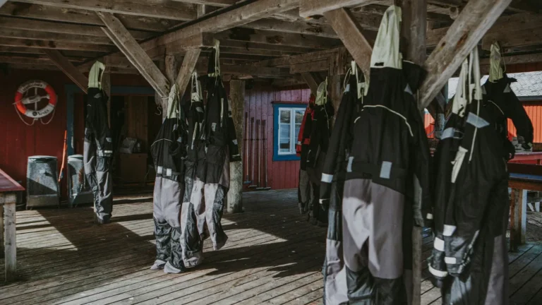 Drysuits hanging to dry from the rafters of a dive boathouse