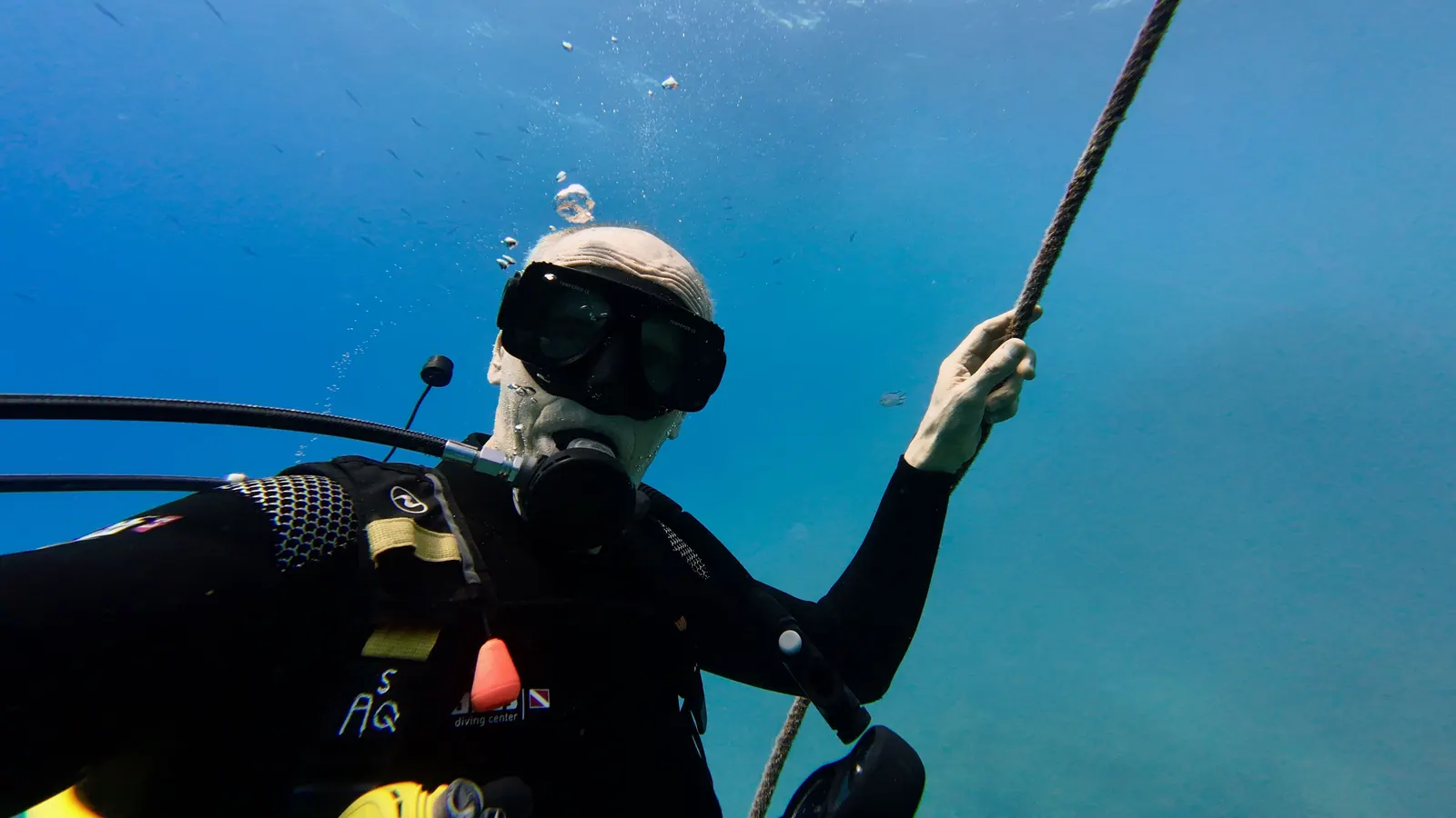 A scuba diver gripping a descent line underwater during a dive
