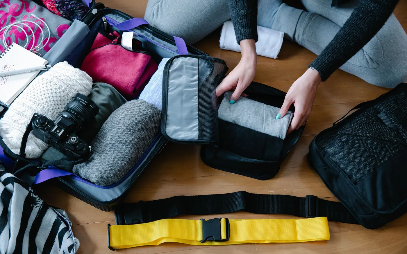 Travel gear and packing cubes laid out and sorted before a trip