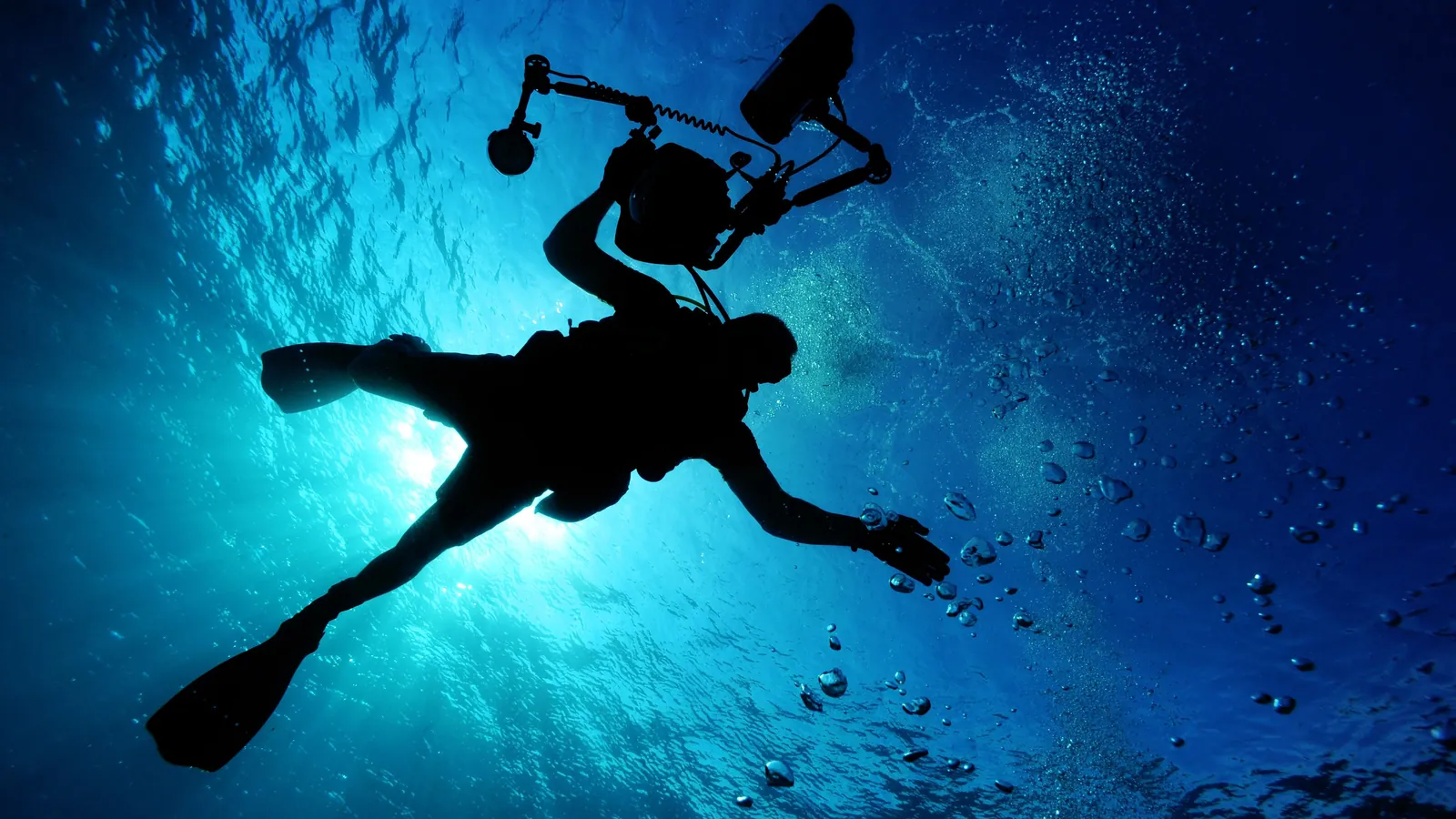 A lone scuba diver silhouetted against the sun with nothing to navigate by