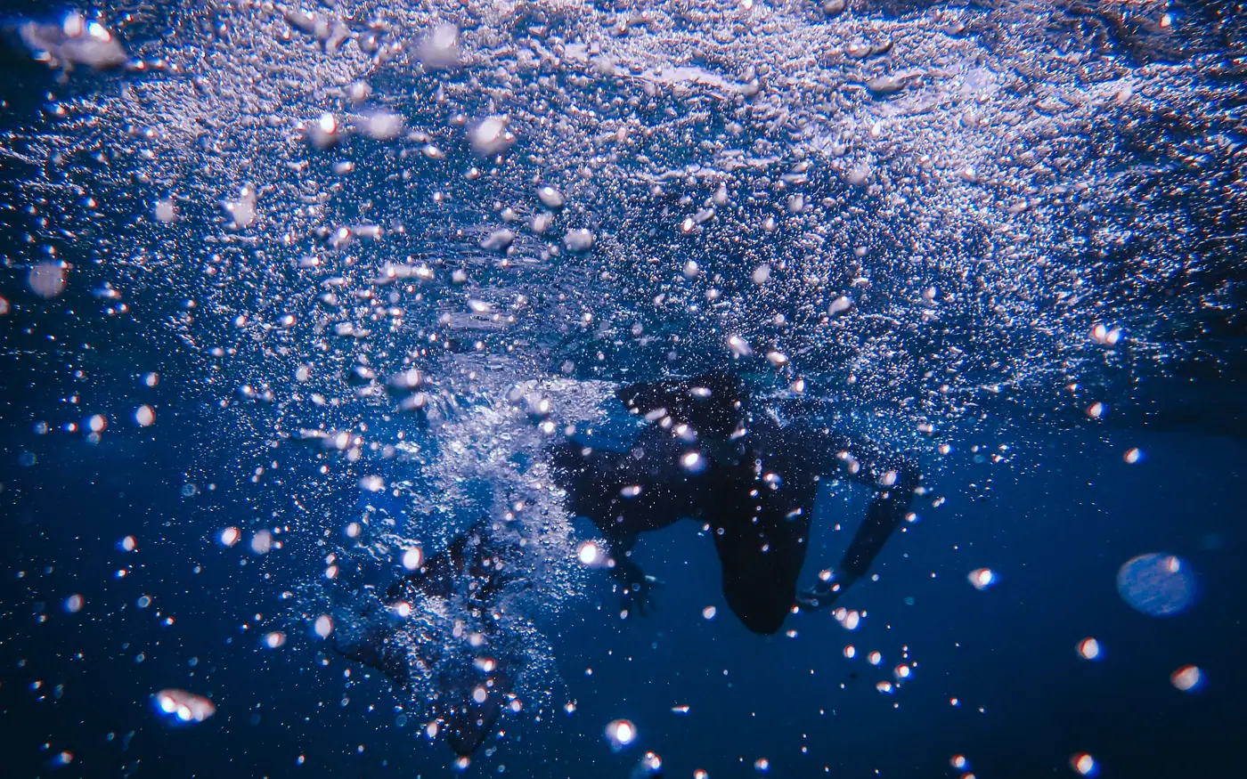 Bubbles and particles suspended in blue water