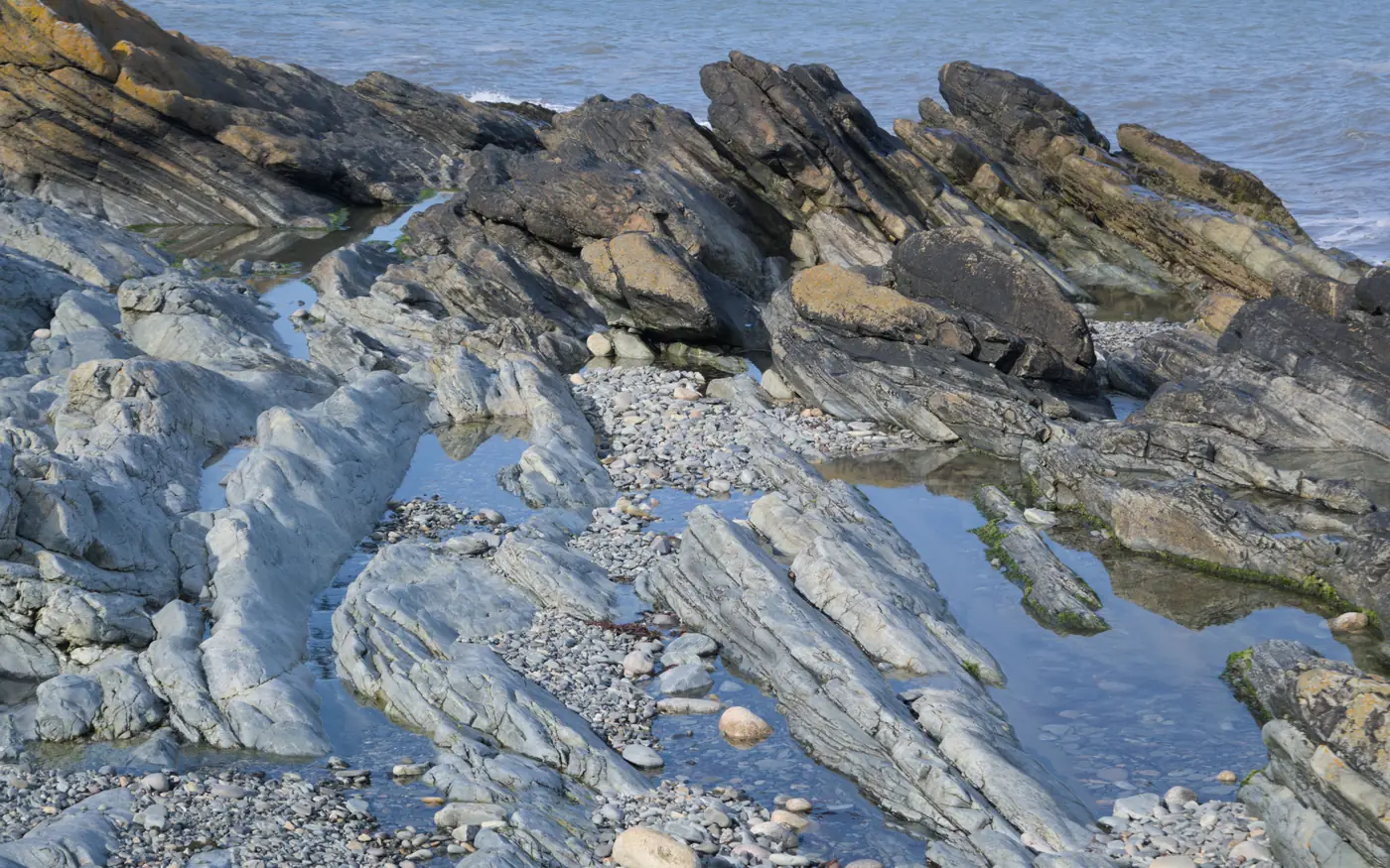 A rugged rocky shoreline dropping into the Atlantic, typical of a shore-dive entry