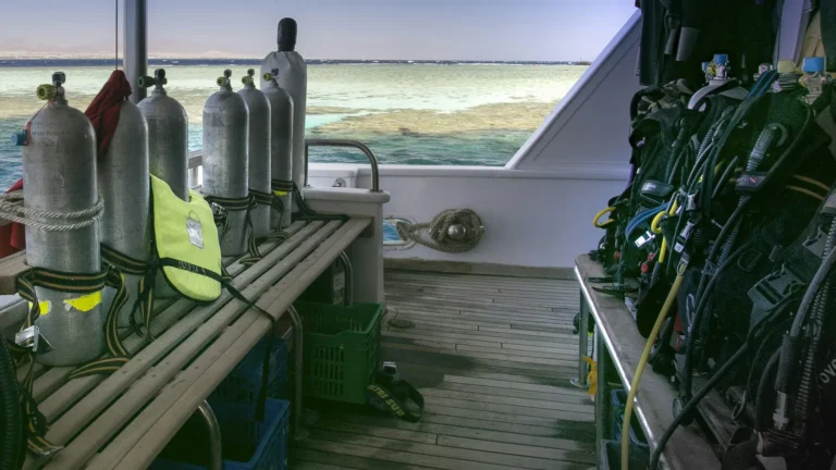 A rack of aluminum scuba cylinders standing on the deck of a dive boat