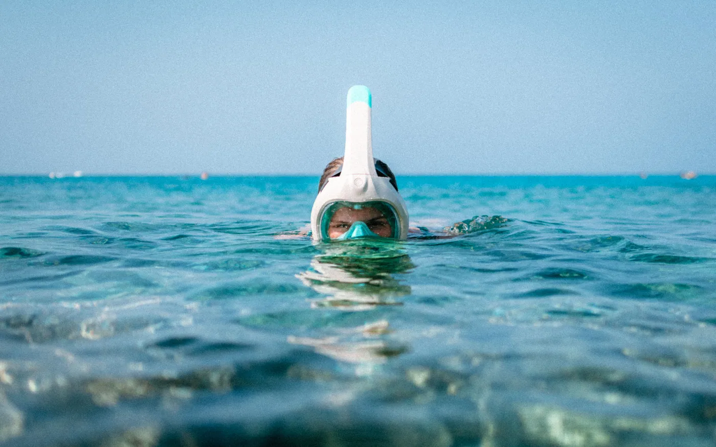 A snorkeler looking down through the surface
