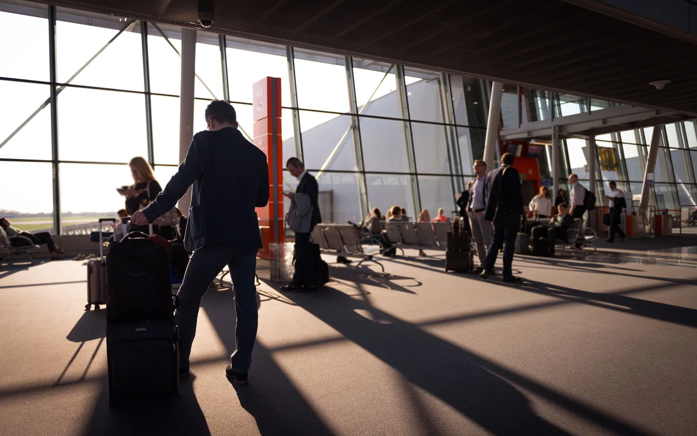 A traveler crossing an airport terminal with luggage