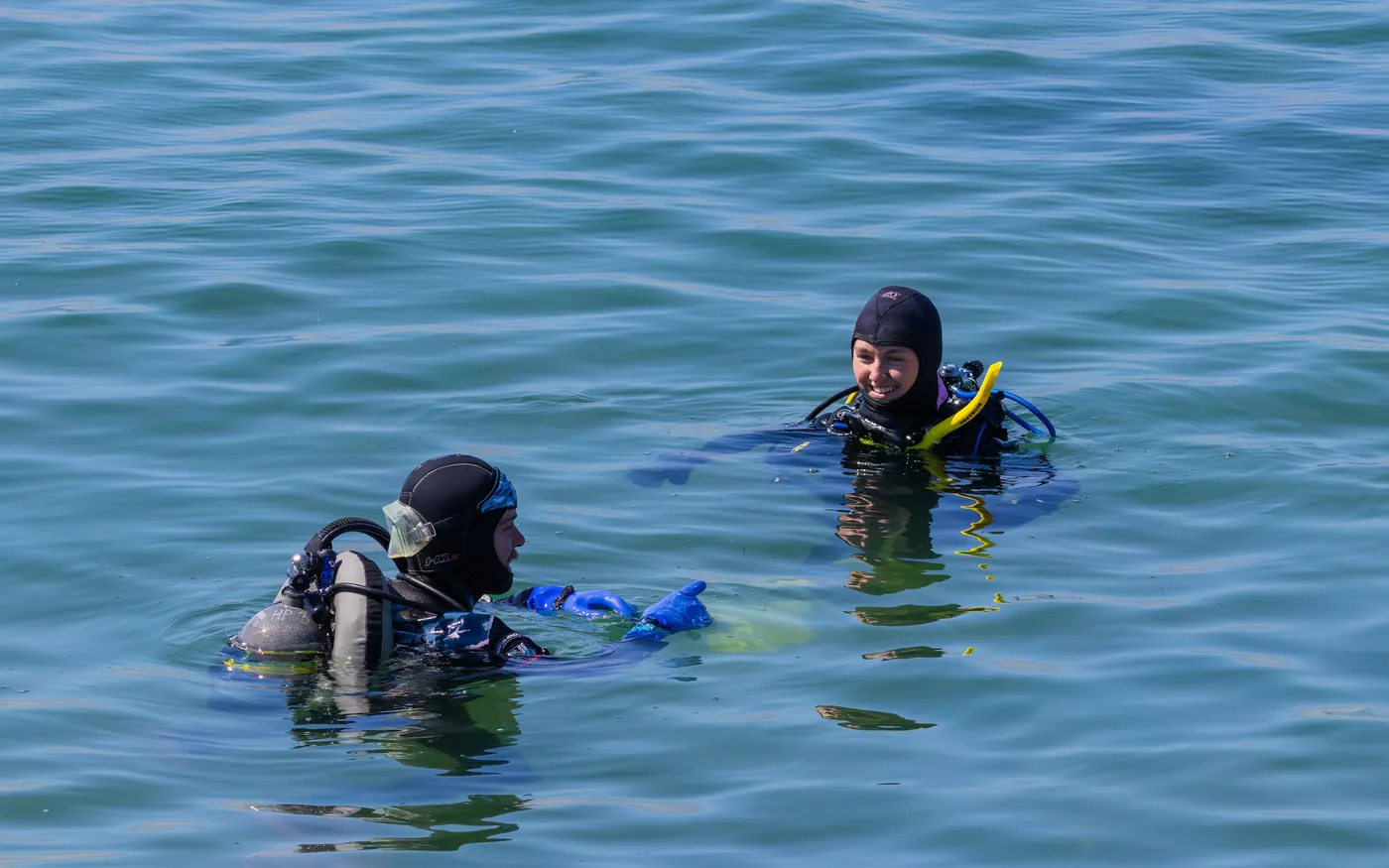 Two scuba divers at the surface waiting to be picked up by the boat