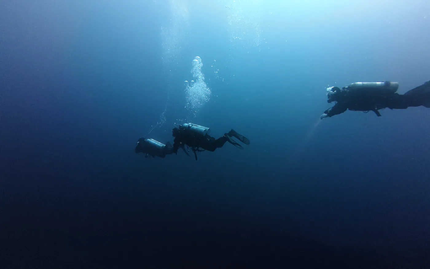 Two scuba divers together in open blue water