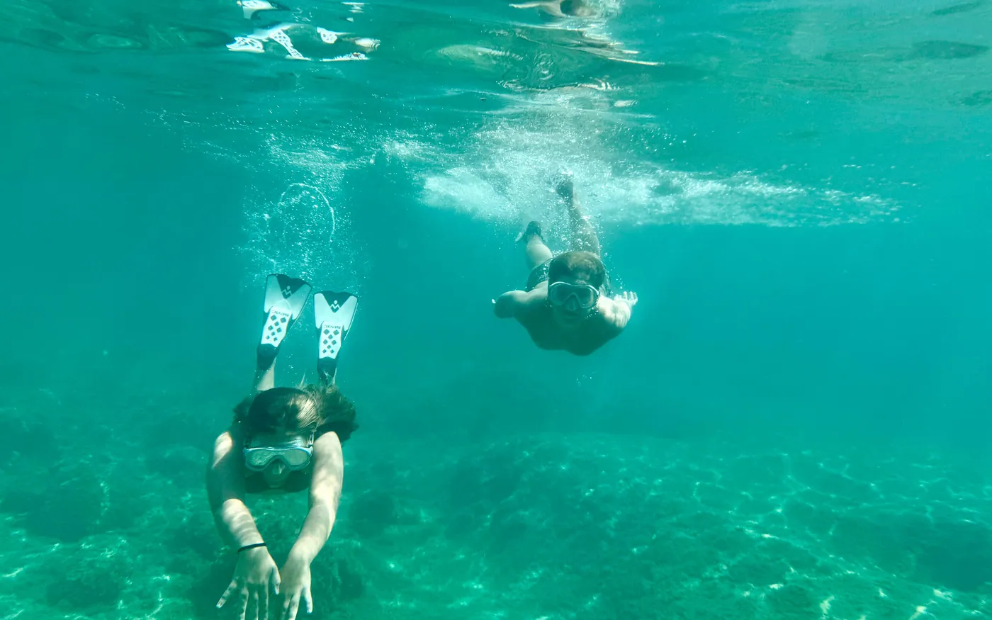 Two snorkelers swimming together in shallow clear water